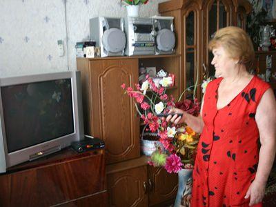 Валентина Черчович безнадежно пытается включить свой сгоревший телевизор, превратившийся в «черный квадрат». 