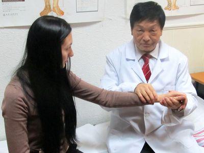 Доктор Чжан показывает, где расположена точка «Вэнь-Лю».