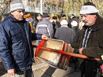 Владимир Деркач и Александр Антымонюк показывают ящик с собранными за полдня деньгами в поддержку акции. 