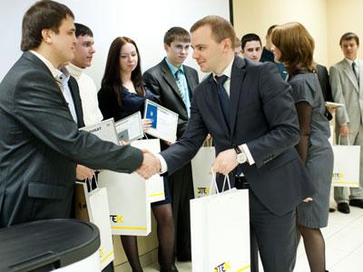 Замдиректора по управлению персоналом ДТЭК Евгений Бондаренко вручает выпускникам электронные книги. 
