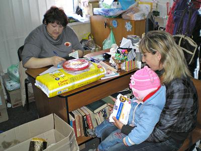 Дончанка Виктория с маленькой дочкой Дашей получают продуктовые наборы и игрушки.