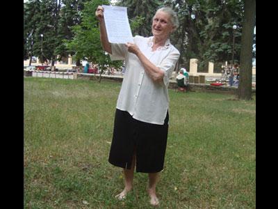 Лариса Жилина, стоя босиком на траве, демонстрирует «Детку». Сколько экземпляров учения Иванова она уже раздала - сказать невозможно...